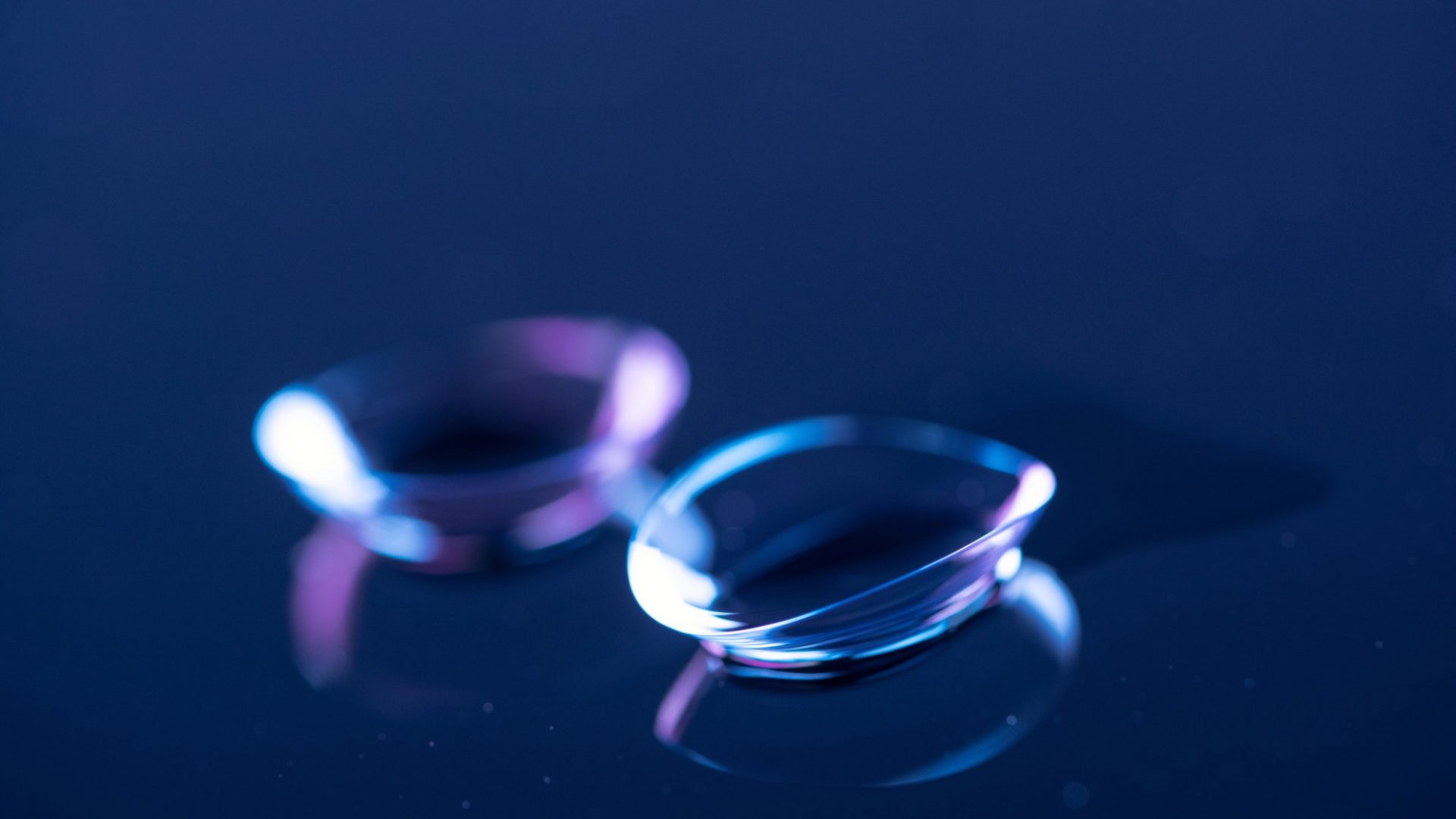 selective focus of contact lenses arranged on blue backdrop